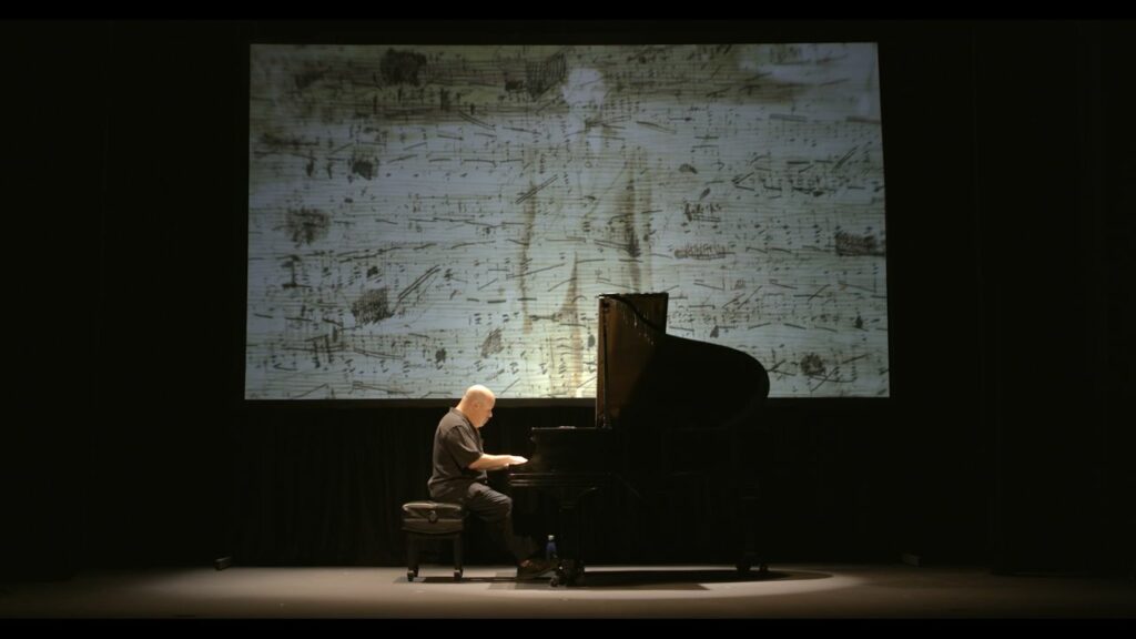 Dedication Marlyebone Theatre: Showing Roger Peltzman on stage with a piano performing Dedication