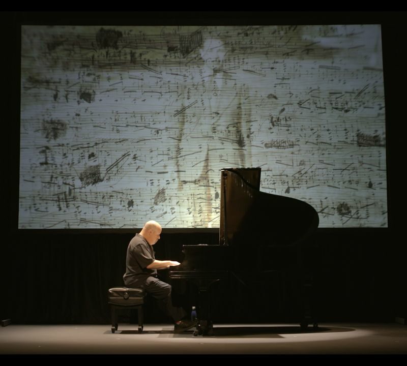 Dedication Marlyebone Theatre: Showing Roger Peltzman on stage with a piano performing Dedication