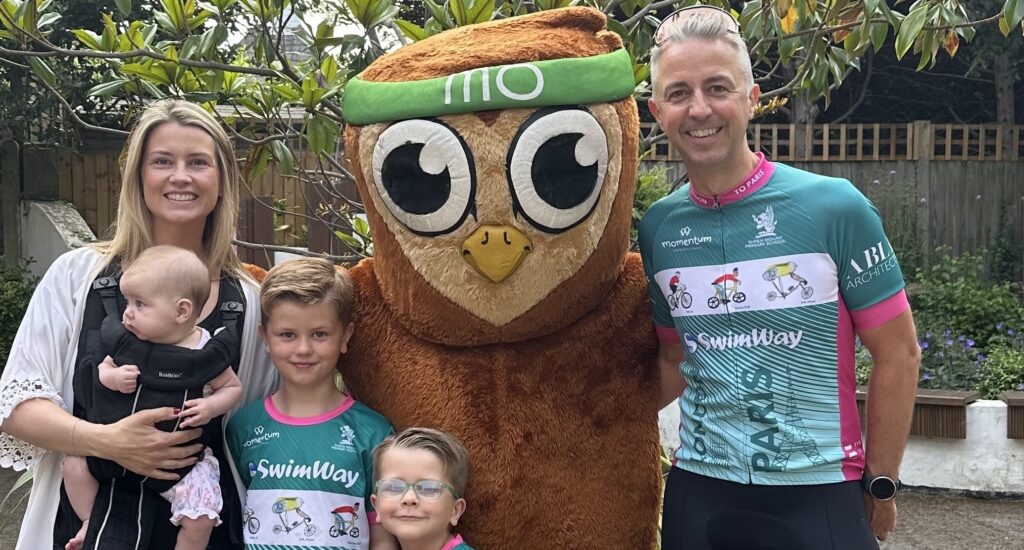 Superstars: The Beill Family stand in cycling gear with the Momentum owl mascot