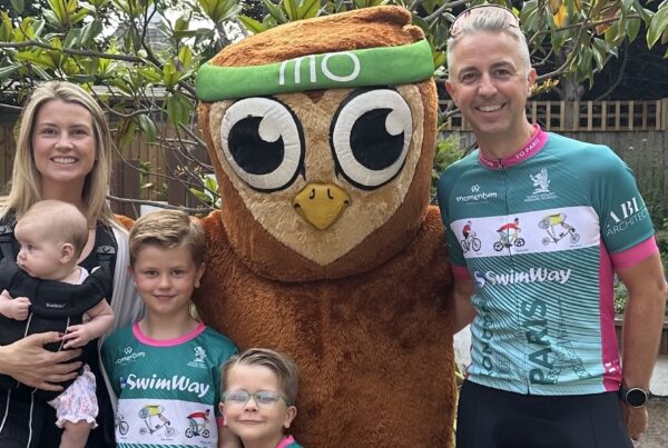 Superstars: The Beill Family stand in cycling gear with the Momentum owl mascot