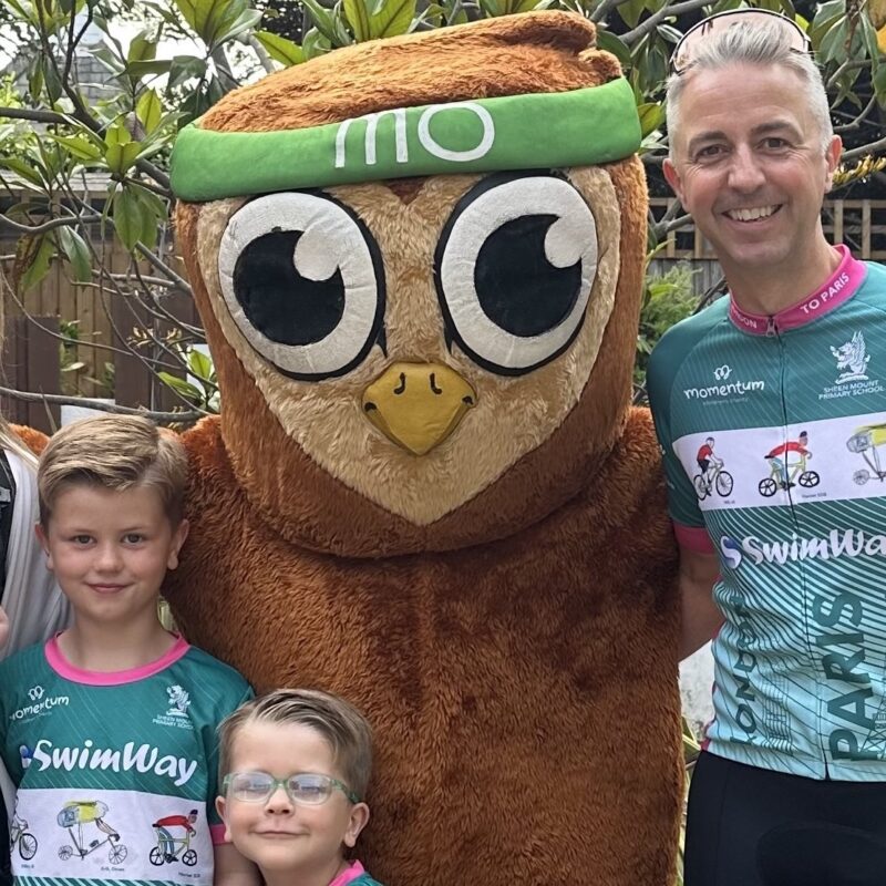 Superstars: The Beill Family stand in cycling gear with the Momentum owl mascot