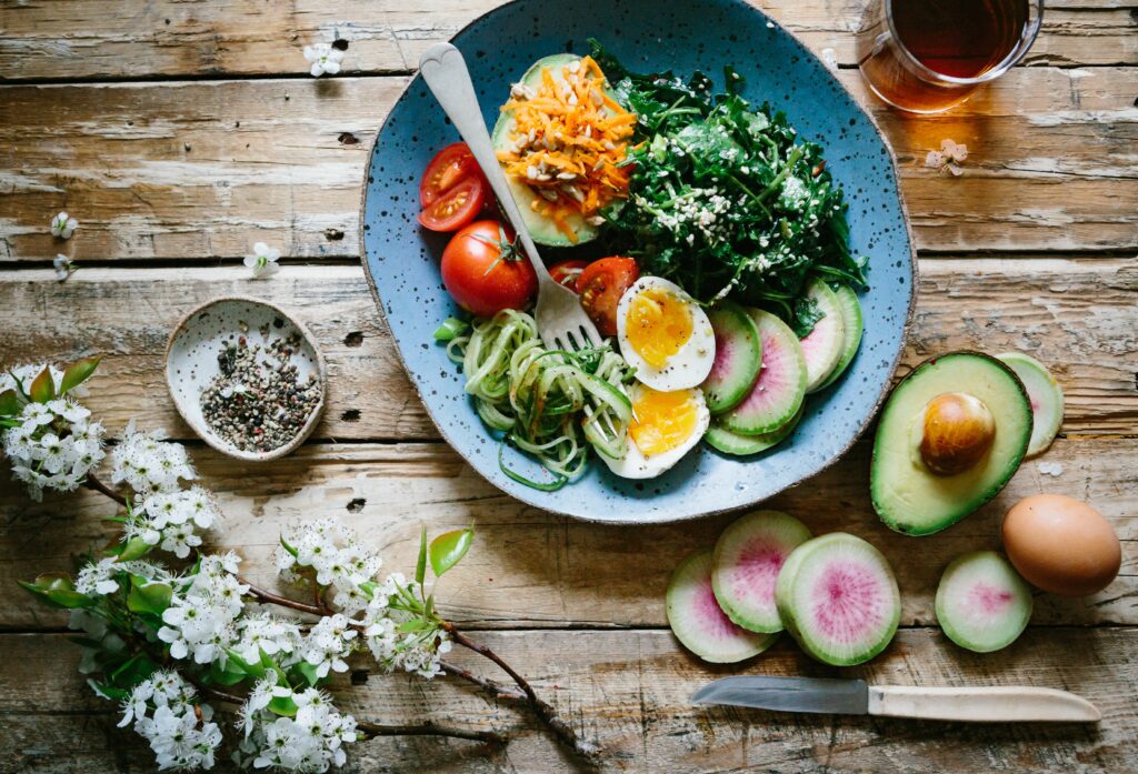 female nutrition: bowl of vegetables with boiled egg, and avocado on the side. 