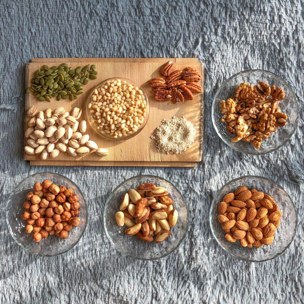 female nutrition: assortment of nuts on a wooden board and in bowls. 