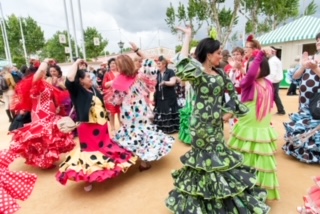 Women in colourful flamenco dresses dancing at the Seville April Fair, Spain 