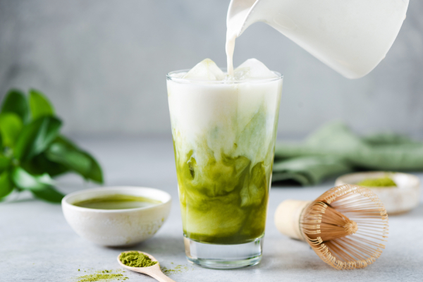 Soy milk pouring in matcha ice tea. Healthy vegan drink-darling-magazineuk article